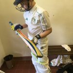 Young cricketer going out to bat