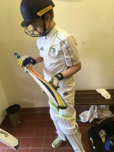 Young cricketer going out to bat