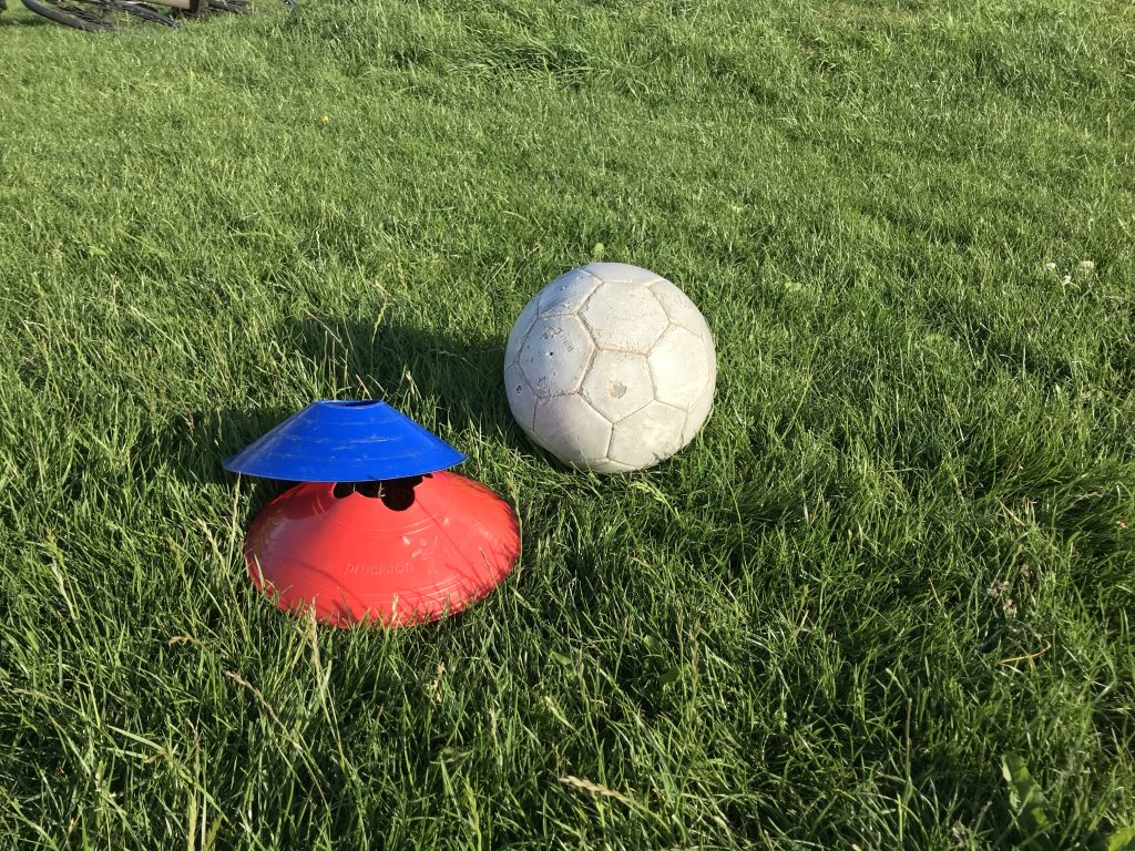A football next to some coaching space markers