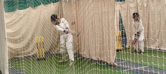 Young cricketers hitting the ball in the nets