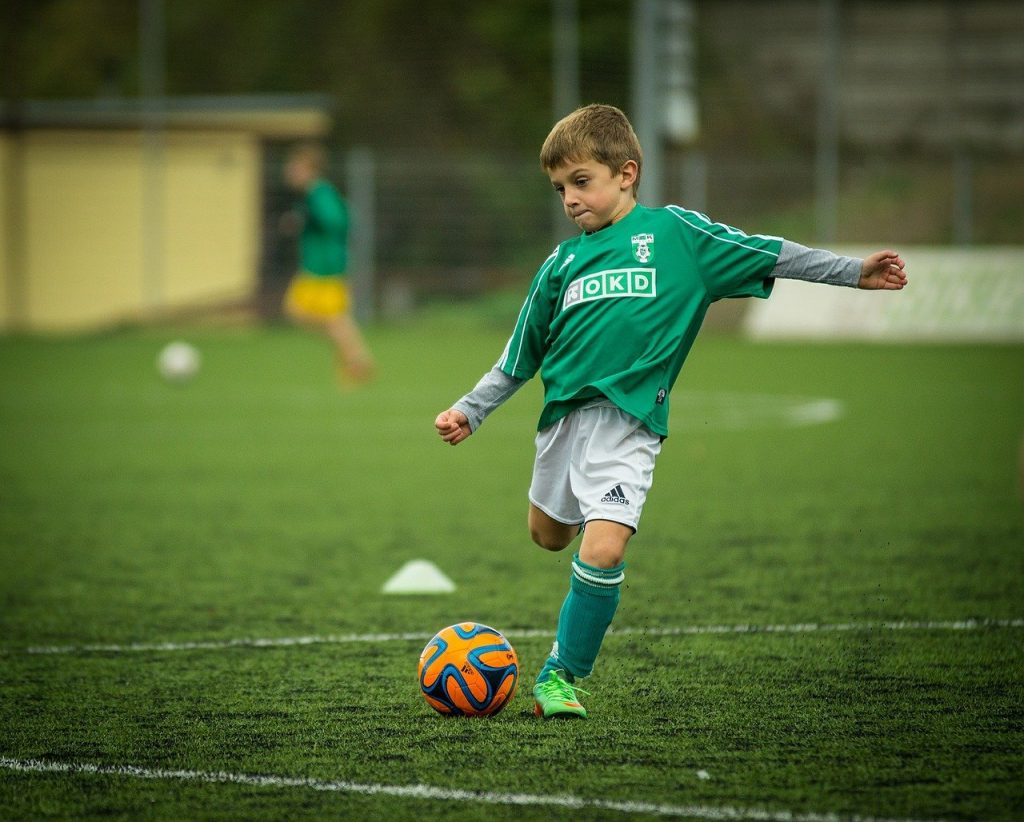 A young footballer about to kick a ball