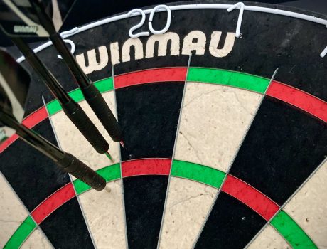 A dartboard with two darts in the 5 and one dart in the 20. All three are near the treble 20 but their combined score is just 30.