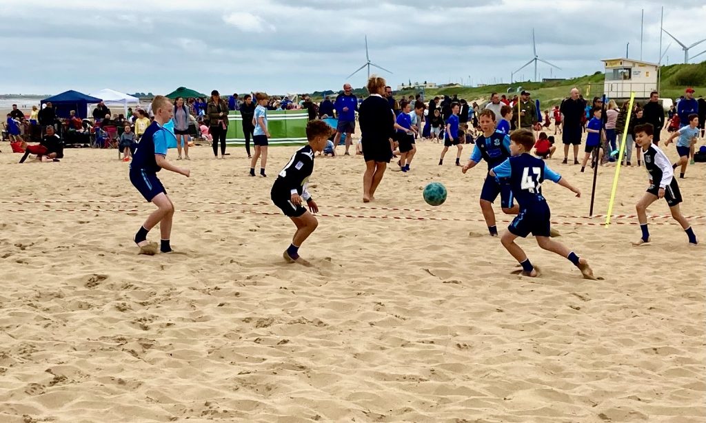 Boys playing beach soccer in Bridlington, England